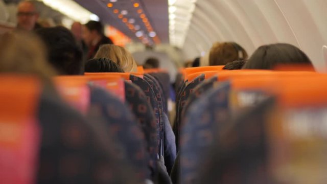BOKEH FOCUS of passengers preparing to leave an airplane.