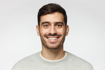 Fototapeta premium Szczegół portret uśmiechnięty przystojny mężczyzna na białym tle na szarym tle