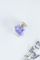 Fototapeta na wymiar Flowers of lavender, decorative bottle with sea salts on the white background. Relaxing concept.