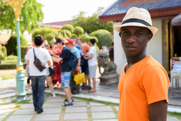 Young black African tourist man visiting Buddhist temple
