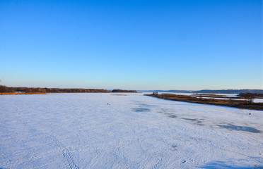 Sunny snowy day outdoor. ice-bound lake in winter day with blue sky.Panoramic view.