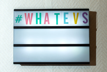 Message #whatevs on illuminated board. Incuriosity concept with text.