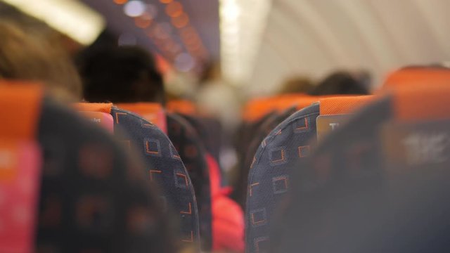 BOKEH FOCUS of seat rows inside a passenger airplane in flight.