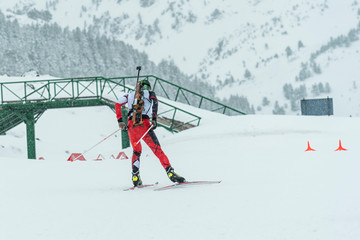 Winter sports. A participant in a biathlon competition, in a winter season in Spain, in a snowy landscape.