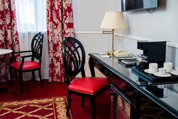 Interior room with red chair and black table and table lamp.