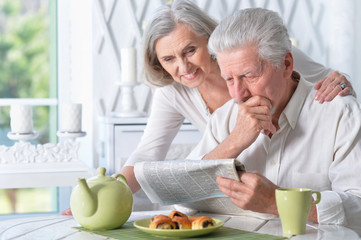 Close-up portrait of a  senior couple with newspaper