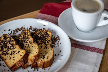 Slices of gingerbread with flakes of chocolate and cup of coffee, top view