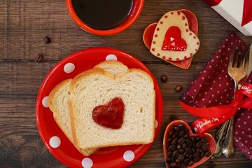 Valentines day breakfast in bed  sandwich with red jam hearts coffee on a white tray
