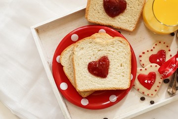 Valentines day breakfast in bed  sandwich with red jam hearts coffee on a white tray