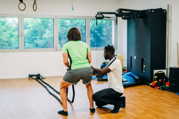 Man with battle rope in functional training fitness gym