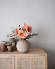 Amaryllis in runder Vase auf Schrank
