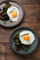 Two plates with fried eggs and bread, rustic style