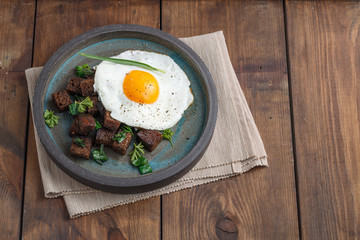 Fried Egg on Wholegrain Toast croutons, top view, copy space
