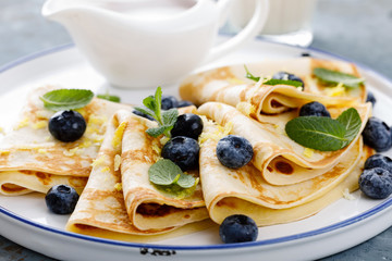 Sweet pancakes wrapped with fresh berries, crepes with blueberry