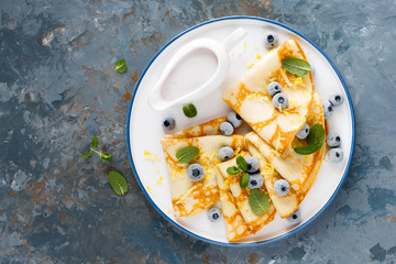 Sweet pancakes wrapped with fresh berries, crepes with blueberry, top view.