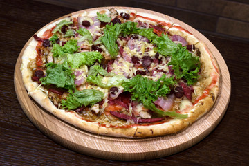 meat pizza on a table in a wooden plate