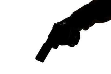The gun in the hand of men who is ready to shoot at his victim. Breaking the law and crime. Attack...