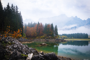 Lake Laghi di Fusine on foggy morning and mountain Mangart