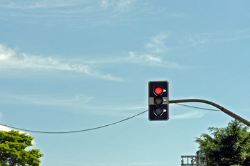 Red traffic light under blue sky