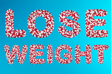 inscription lose weight white and red capsules on a blue background top view. concept of medication and pharmaceuticals weight loss drugs