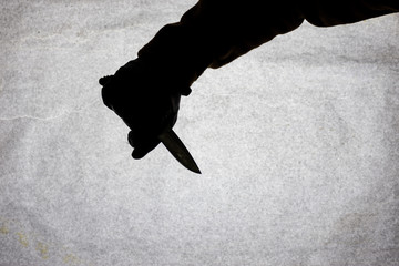 The knife in the hand of men who is ready to attack his victim. Breaking the law and crime. Attack...