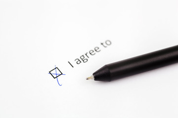 I agree to - checkbox with a check mark on white paper with pen. Checklist concept