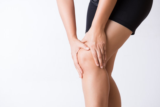 Runner sport knee injury. Closeup young woman in knee pain while running. Healthcare and medical concept.