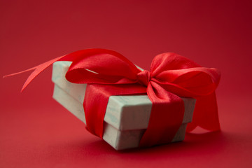 Close up gift box, birtday gift with red bow on red background. Free space for your text. Love, Valentine's Day, Mother's Day.