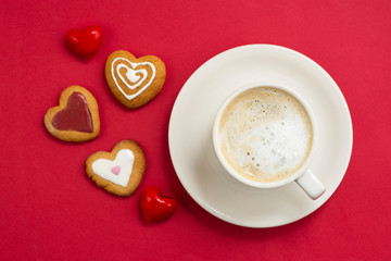 Love, Valentine's Day concept. Cup of coffee or latte and heart shaped cookies, biscuits. Red background, copy space.