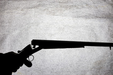 Classic double-barrell smooth-bore hunting rifle on man hand isolated on light stone background