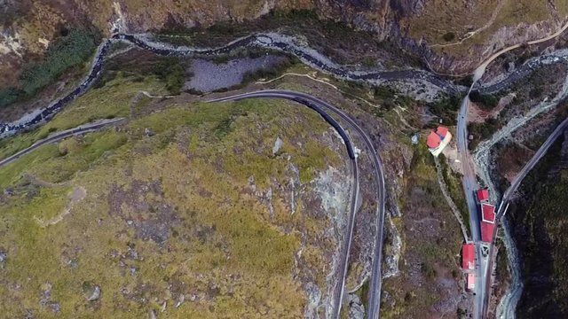 An aerial shot of a train going around the "Nariz del Diablo" or  Devil's Nose in Alaus&radic;&ne;, Chimborazo Province, Ecuador. The Devil's Nose is one of the world's most picturesque and dangerous railways.