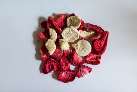 freeze dreid strawberries and bananas on a white background