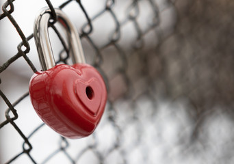 Fototapeta na wymiar background. a red lock in the shape of a heart is hanging on the fence. Valentine's day holiday.