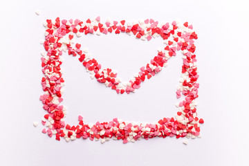 envelope shape on white background made of red white and pink hearts sweets. Top view. Valentine day. love concept. Gift, message for lover. Space for text