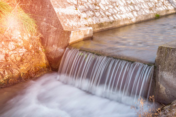 A small weir on a creek. Long exposure - obrazy, fototapety, plakaty