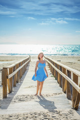 young lady in sky blue sundress on wooden bridge