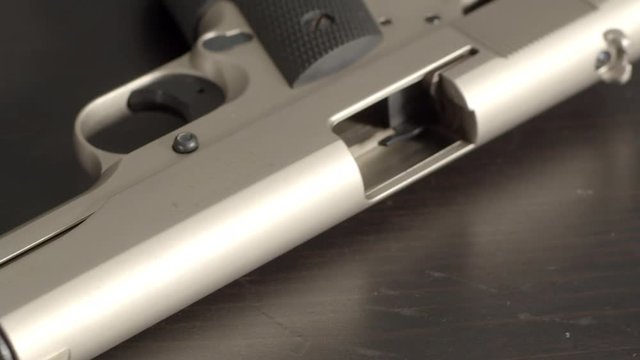 Panning over barrel and chamber of open and empty pistol