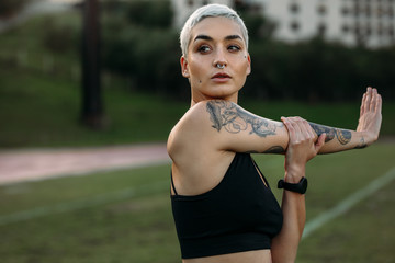 Female athlete doing workout stretching her arm