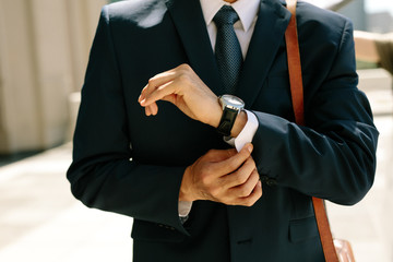 Businessman buttoning his shirt shelves walking outdoors