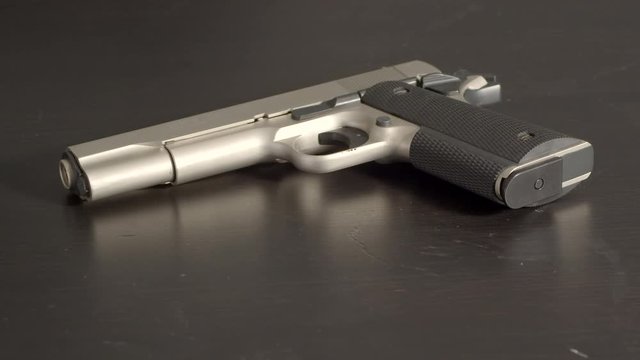 Cocked pistol on table, slow zoom in
