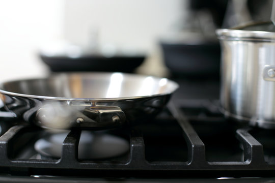 Modern Stainless Steel Gas Stove Oven In A Home With Various Cookware.
