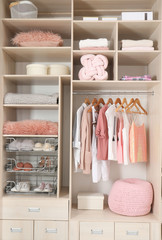 Stylish clothes, shoes and accessories in large wardrobe closet