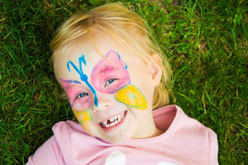 portrait of a cheerful girl with  painted butterfly on her face