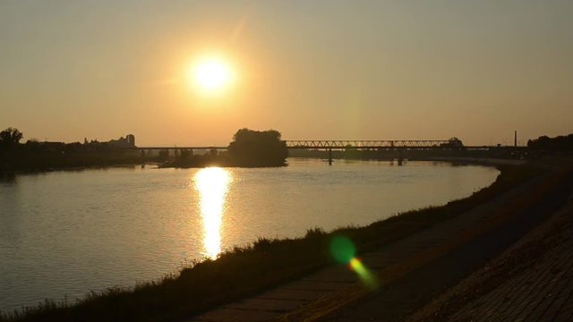 Golden sunset over the river. Peaceful sunset over river Sava in Brod, Croatia. View of the beautiful golden sunset in summer. Bridge on Sava river 