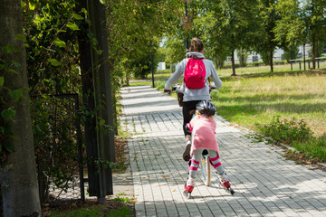 children frolic in the fresh air, riding a bicycle and on rollers