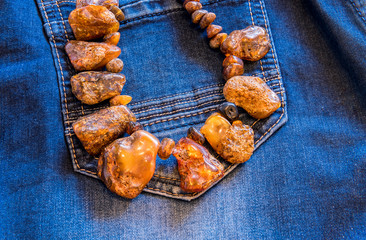 Decorative treated beads of Baltic amber on a blue denim background     