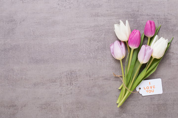 Spring greeting card, pink color tulips on the gray background.