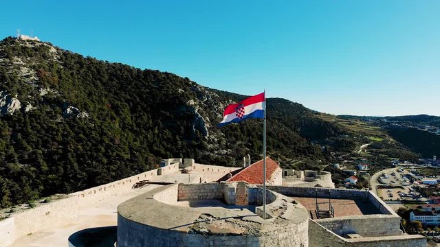 Croatian flag on the ancient fortress waving on the wind.