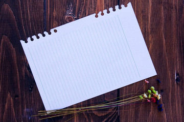 Folha de caderno com o fundo de madeira