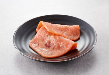 Closeup of sliced ham on white background